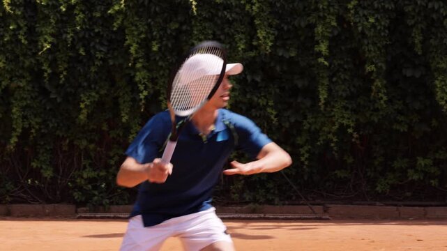 Male tennis player striking forehand shot with motion blur on clay court. Concept of dynamic tennis action, athletic movement, competitive sport, speed, timing and powerful performance.