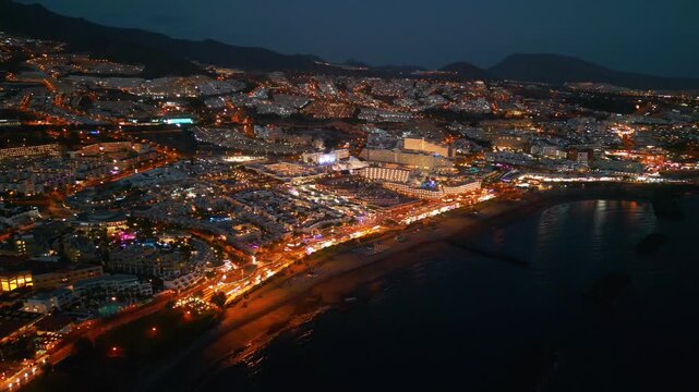 sunset at ocean shore and night illuminated city view, Tenerife, Canary island aerial drone view 4k