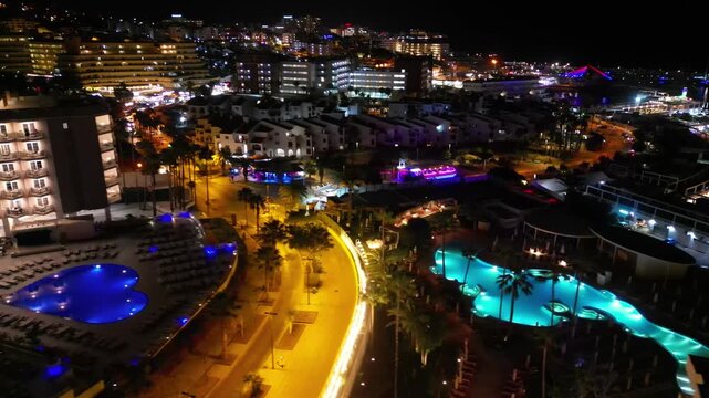 night city with illuminated building, hotel and light streets of festive Costa Adeje, Tenerife Canary islands, 4k aerial drone view
