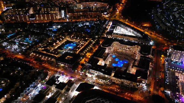 night city with illuminated building, hotel and light streets of festive Costa Adeje, Tenerife Canary islands, 4k aerial drone view