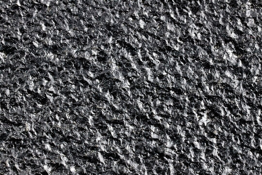 Black painted cast iron texture surface background macro close up rough metallic material dark backdrop pattern structure industrial solid gritty coarse textured sheet details uneven hard element