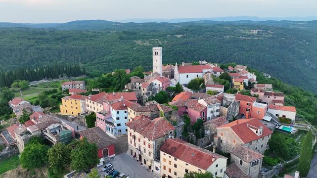Cinematic aerial drone shot of Oprtalj hilltop medieval town in Istria Croatia during summer with historic stone houses, narrow streets, surrounding hills and authentic European scenery