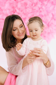 Happy Mother Holding Daughter during Studio Photo Session