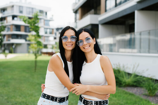 Customer Two Sisters Hugging in Urban Area