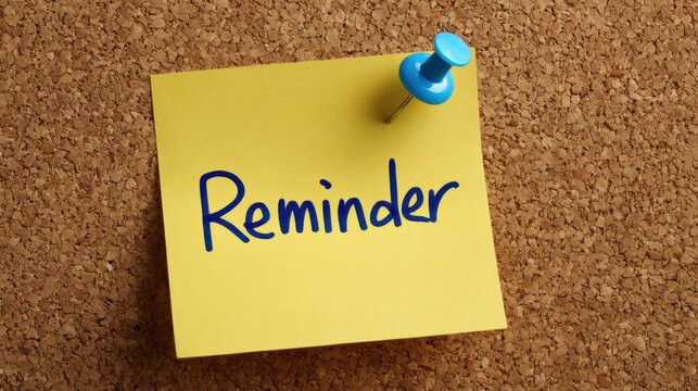 Yellow sticky note with blue pin and word reminder written in blue on cork board.