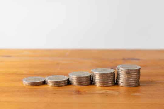 Closeup of coin stacks for money savings and growth on wooden table