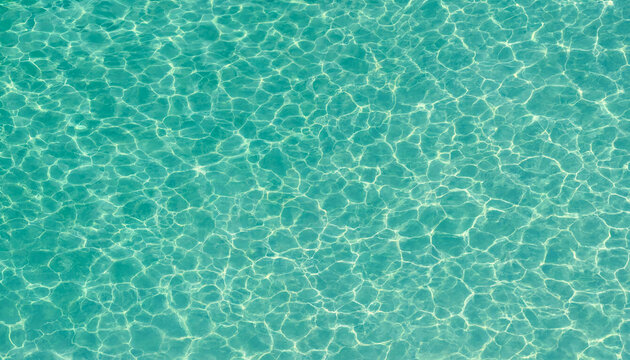 A serene and peaceful aqua blue water surface with sunlight reflections