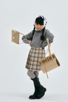 手作りのダンボールのバッグを持ってポーズをとる女の子