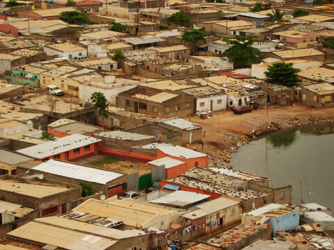 Angola, Luanda, Loanda, overview of a shanty town and other small slots with dashes of green bushes and trees on a peninsula, surrounded by stagnant dirty water