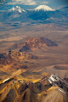 Bolivia, Chile, Inland, the Western Range or Cordillera Occidental, at the border between Bolivia and Chile, with volcanoes and high peaks with perennial snows against cloudy sky