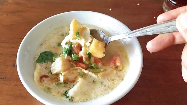 Soto Betawi, an iconic culinary dish from Jakarta, Indonesia. It has a thick white broth, usually filled with beef, offal such as tripe and lung, potatoes, tomatoes, and a sprinkling of fried onions