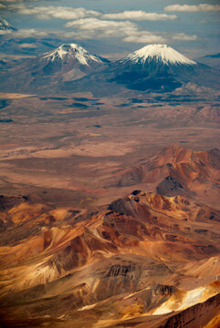 Bolivia, Chile, Inland, the Western Range or Cordillera Occidental, at the border between Bolivia and Chile, with volcanoes and high peaks with perennial snows against cloudy sky