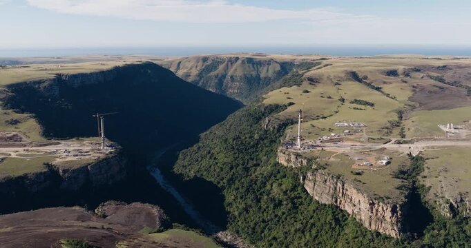 Wide aerial panning view of the construction of Msikaba Bridge in the Eastern Cape, South Africa. It will span 580 meters across the Msikaba River gorge and stand 194 meters high. Economic development
