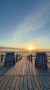 beautiful wooden beach chairs on sunset on the pier