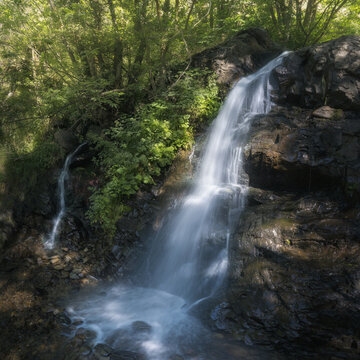 Waterfall Cascades Amidst Lush Greenery in Llivia, Catalonia