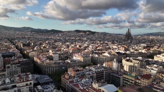 Establishing Drone Shot of Barcelona Spain, Sagrada Familia Cathedral Above Buildings and Clouds Above Cityscape