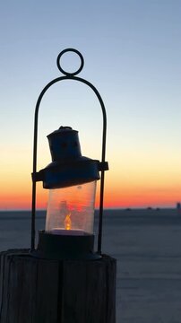 retro lantern lamp on the beach in sunset light