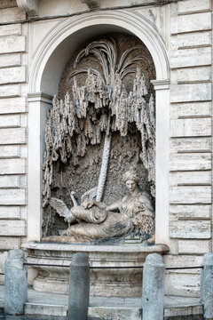 One of the historic Quattro Fontane baroque fountains built into a street corner niche featuring a reclining mythological figure in Rome, Italy