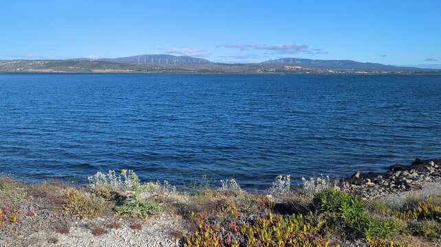 France. Leucate. Lake View in the Daytime. Relaxing waves lap gently against the shore. Enjoy the beauty of nature and the serene landscape. Witness tranquility all around you.