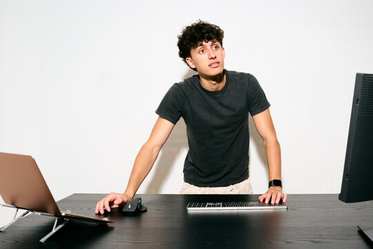 Young man working on computer while talk with his colleagues