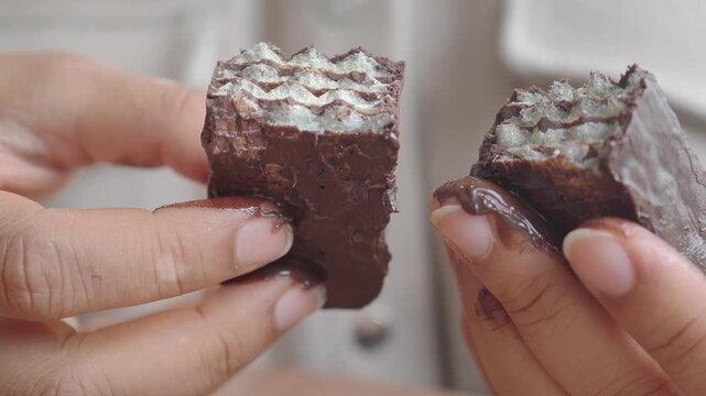Exploring a chocolate treat with layers and filling in hands