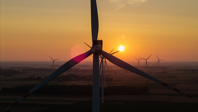 Wind farm, wind turbines, dawn, sunrise, rotating turbine blades, flashing red aviation lights, renewable energy, sustainable energy, clean electricity, green power, wind power generation, eco-friendl