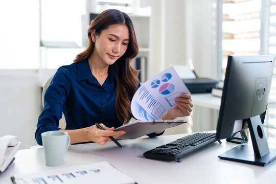 Businesswoman working on pc holds paper prepare report analyzing work results on paperwork. financier manage firm finances concept