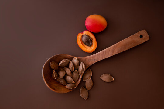 Apricot and it's kernels in a wooden ladle