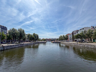Fototapeta premium Scenic canal view with historic buildings and blue sky in Antwerpen, België