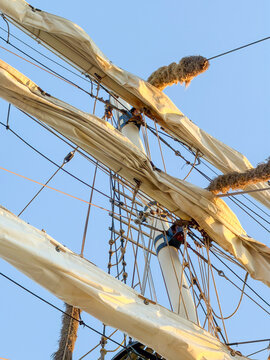 Tall ship mast rigging with furled sails against blue sky in Antwerpen, Belgi&euml;