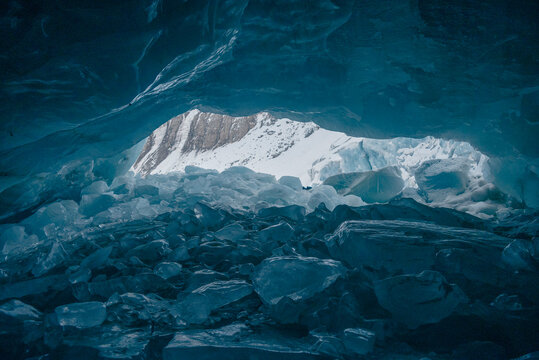 Stunning interior of a blue ice cave in Linzhi, Tibet, with natural light illuminating the frozen walls and ice formations