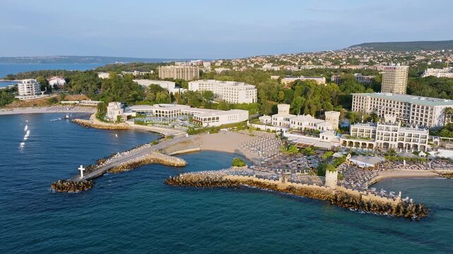Beautiful coastline of Saints Constantine and Helena resort with stone breakwaters sandy bays and hotels on green hills background aerial drone panoramic shot.