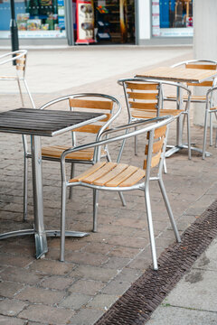 Corby, Northamptonshire, United Kingdom - July 15, 2026: Empty outdoor cafe tables and chairs in modern shopping center
