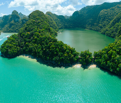 defaultAerial drone view of calm green lake bordering with blue sea scenery at Dayang Bunting Lake in Langkawi Island, Kedah, Malaysia.