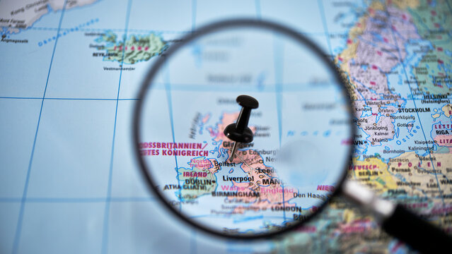 Magnifying glass highlighting BELFAST  on paper map