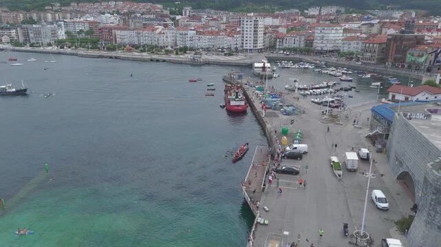 Drone flying backwards revealing castro urdiales harbor