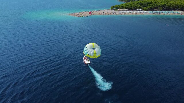 Parasailing speedboat cruising towards zlatni rat beach in croatia