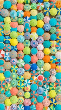 Vibrant Aerial View of Colorful Umbrellas on a Sunny Beach Day.