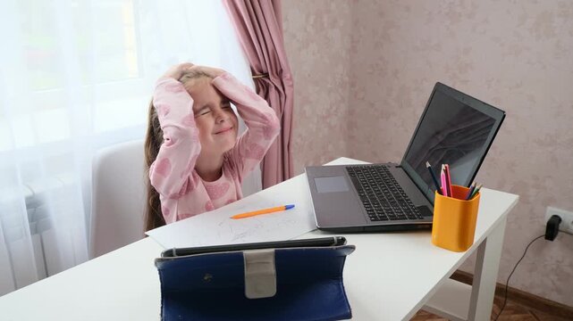 Frustrated kid studying at home with homework problem and stress