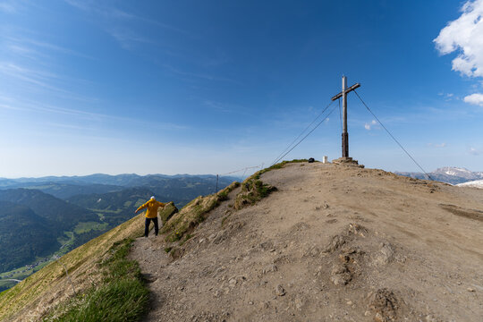 Hiker walking on a scenic ridge path at Fellhorn mountain summit