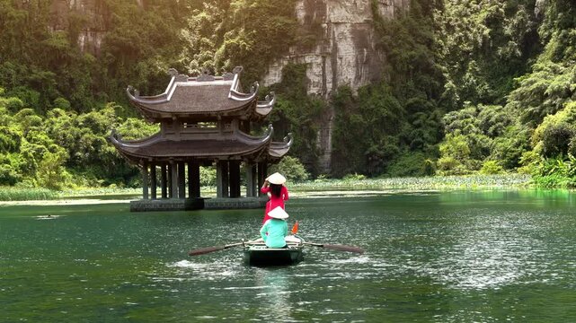 Tourists take a boat trip on the river at Trang An, Ninh Binh Province, Vietnam.