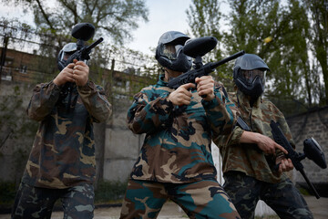 Fototapeta premium An armed group of several soldiers practice with weapons on a training field together