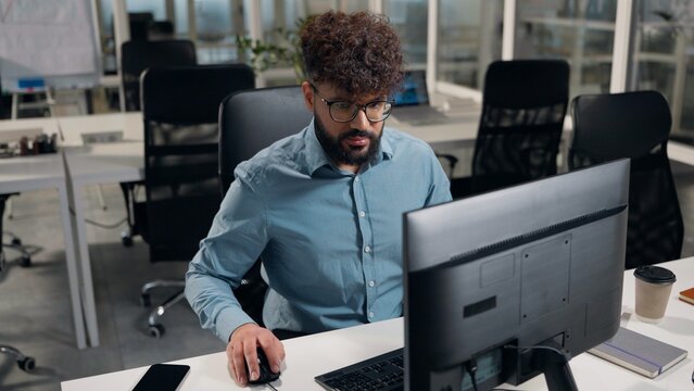Arabian ethnic business man working with modern technology typing computer in corporate office businessman work pc chatting with client consulting with message e-mail male agent browsing internet