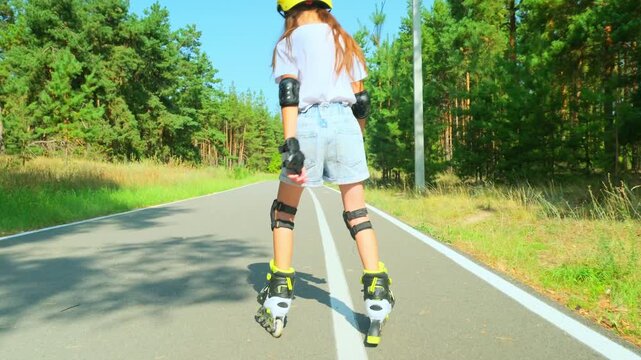 Carefree positive adorable girl roller skating in public park. Joyful child having fun, enjoying rollerblading outdoors on summer day