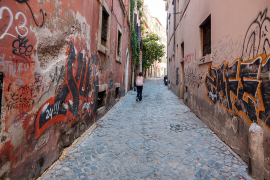 Narrow Cobblestone Street with Colorful Graffiti in Historic Rome, Italy, Authentic Urban Alley and Popular European Travel Destination