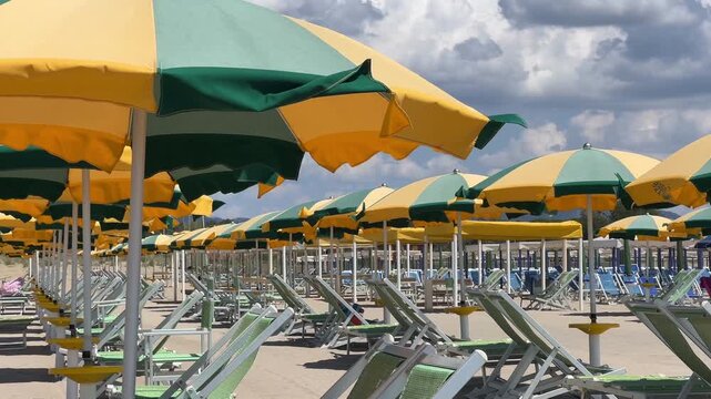 Beach with rows of colorful umbrellas and sunbeds on traditional beach in Viareggio, Lucca, Tuscany Italy. 