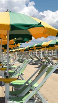 Beach with rows of colorful umbrellas and sunbeds on traditional beach in Viareggio, Lucca, Tuscany Italy. 