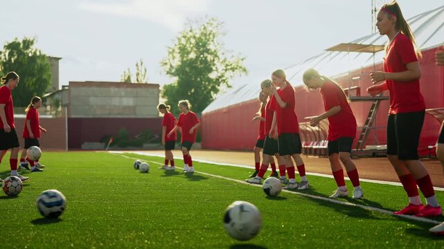 Focused womens soccer team practicing coordinated ball control drills on artificial turf field during outdoor training session in bright afternoon sunlight