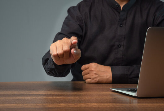 Businessperson Pointing Forward at Office Desk