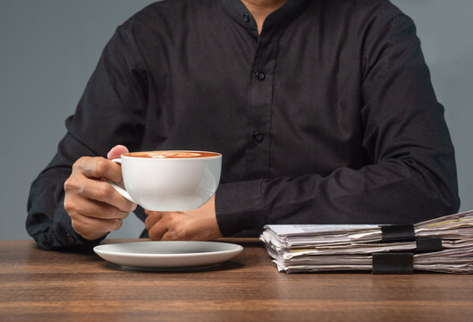 Businessperson Holding Coffee Cup at Office Desk